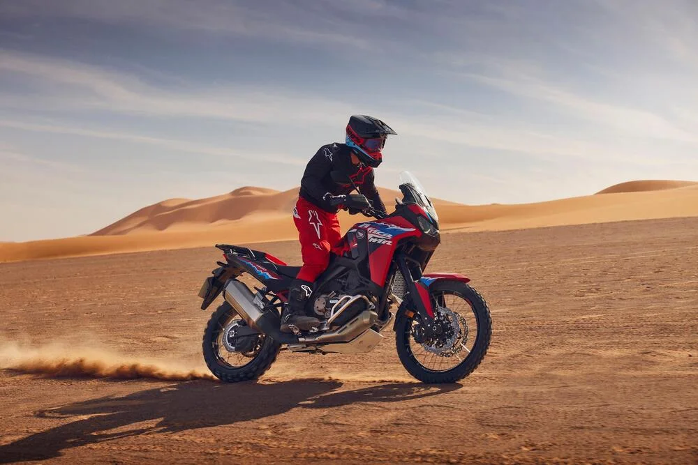 Piloto testando a nova Africa Twin 2024 no deserto.